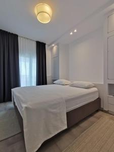 a white bedroom with a large bed and a window at Ikarus Modern Apartment at the Centre of Athens in Athens