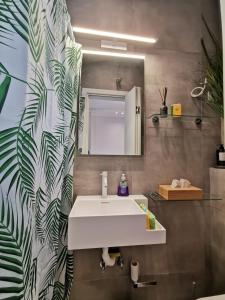 a bathroom with a white sink and a mirror at Ikarus Modern Apartment at the Centre of Athens in Athens