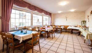 restauracja ze stołami, krzesłami i oknami w obiekcie Hotel Schwung w mieście Bocholt