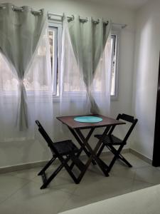 une table et deux chaises devant une fenêtre dans l'établissement Apartamentos da Gaby, à Morro de São Paulo