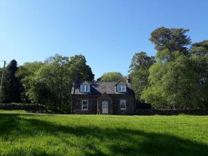 une vieille maison en briques dans un champ d'herbe dans l'établissement Beautiful Traditional secluded country cottage, à Sanquhar