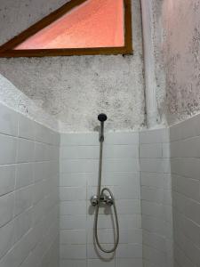 e bagno piastrellato con doccia e finestra. di Gîte Camping Amazigh ad Azrou