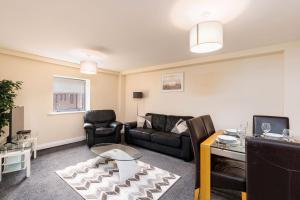 a living room with a couch and a table at Cosy Apartment & Central Location & Contractors & DSA in Doncaster
