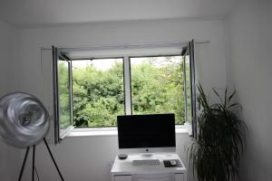a laptop computer sitting on a desk in front of a window at Spacious and airy 1 bedroom flat - Great location in London