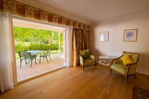 a living room with a table and chairs and a sliding glass door at The Dixcart Hotel in Sark