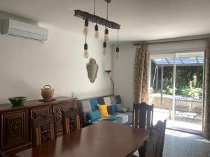 a dining room with a table and a couch at Maison DELMAS, l'Oustal du Recantu in Sainte-Eulalie