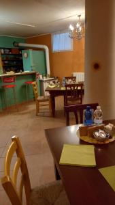 a dining room with a table and chairs and a kitchen at Il Girasole in Strevi