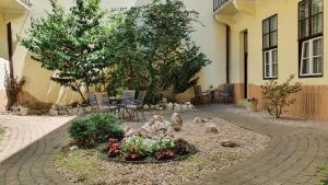 une cour avec un jardin agrémenté de rochers et de fleurs dans l'établissement Central Hotel 21 and Apartments, à Budapest