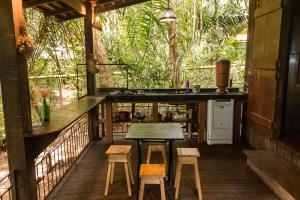 eine Küche mit einem Tisch und Stühlen auf einer Veranda in der Unterkunft Bangalô Ponta de Areia, na beira da praia in Alter do Chao