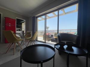 salon ze stołem i krzesłami oraz dużym oknem w obiekcie RoofTop Apartement - Quartier Croisette - Esc'Appart w Cannes