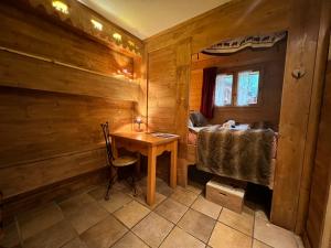 Cette chambre en bois dispose d'une table et d'un lit en bois. dans l'établissement Chalet La Grange à Germaine - Propriétés Mont Amour, à Avoriaz