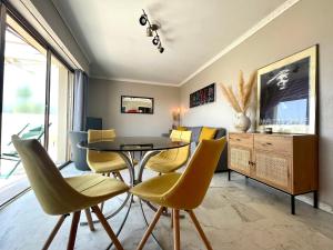 jadalnia ze stołem i żółtymi krzesłami w obiekcie RoofTop Apartement - Quartier Croisette - Esc'Appart w Cannes