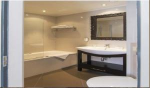 a bathroom with a sink, toilet and bathtub at Hotel Sint Nicolaas in Amsterdam