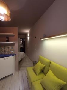 IsnelloにあるCasa vacanze Scurò - Isnelloのリビングルーム(緑のソファ付)、キッチンが備わります。