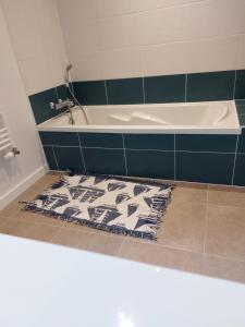 Le Herpin Cancale في كانكال: حمام مع حوض استحمام وسجادة على الأرض