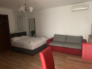 uma sala de estar com uma cama e um sofá em Veritas Apartment Zamárdi em Zamárdi
