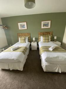 a bedroom with two beds and two tables with lamps at Number 19 Guest House - 4 miles from Barrow in Furness - 1 mile from Safari Zoo in Dalton in Furness