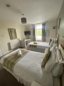 a hotel room with two beds and a window at Number 19 Guest House - 4 miles from Barrow in Furness - 1 mile from Safari Zoo in Dalton in Furness