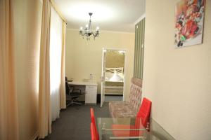corridoio con camera con scrivania e specchio di Sweet Home Hotel a Atyraū