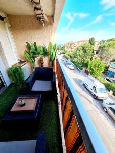 a balcony with a table and couch on a building at Appartement climatisé design au cœur de St-Aygulf à 200 metres la mer in Saint-Aygulf