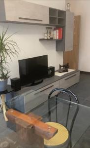 ein Wohnzimmer mit einem Glastisch und einem TV in der Unterkunft Casa Stella in Scandicci