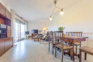 a dining room and living room with a table and chairs at Apartamento Cerdeña Arysal in Salou