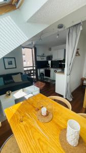 Habitación con mesa de madera y sala de estar. en Appartement 4 personnes Puy St Vincent 1700 en Puy-Saint-Vincent