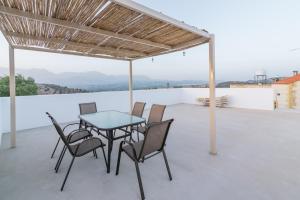 a patio with a table and chairs on a roof at Halkidio House in Sívas