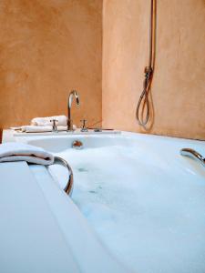 uma banheira com torneira na casa de banho em L'Avenc Benestar Rural em Tavertet