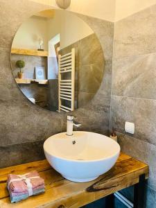 La salle de bains est pourvue d'un lavabo blanc et d'un miroir. dans l'établissement ☆ Rustic Comfort House ☆, à Miercurea-Ciuc