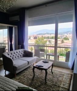 ブレシアにあるSUITE PANORAMAのソファと大きな窓のあるリビングルーム