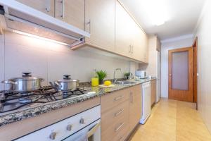 a kitchen with two pots and pans on a stove at Apartamento Cerdeña Arysal in Salou