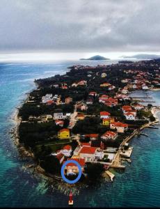 an island in the ocean with a blue circle on it at Apartman Sunset in Sutomišćica