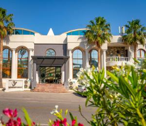 un edificio bianco con palme di fronte di Riva Bodrum Resort- Adult Only +16 a Gümbet
