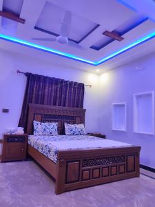 a bedroom with a large bed with a blue light at Lavish Inn Islamabad in Islamabad