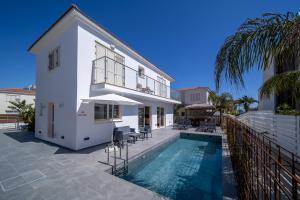 a villa with a swimming pool and a house at No.7 Athena Beach Villa, Pernera in Paralimni