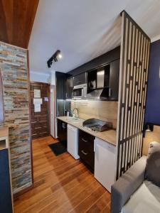 a kitchen with black cabinets and a counter top at Apartamentos Grifovacances Tres Estrelles Club in Pas de la Casa