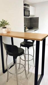a wooden table with two black chairs and a kitchen at Amazing Apartment in Palermo Hollywood! in Buenos Aires