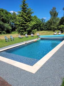 - une piscine avec des chaises dans la cour dans l'établissement Domaine des grands chênes, à Préveranges