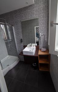 a bathroom with a sink, mirror, and bath tub at Hotel Kanaï in Lille