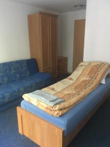 NadoleにあるWilla Niedźwiedźのベッドルーム(ベッド1台、青いソファ付)