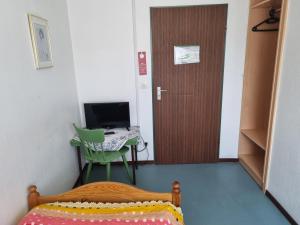 Schlafzimmer mit einem Bett und einem Schreibtisch mit einem Computer in der Unterkunft Hotel Schwung in Bocholt