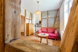 ein Wohnzimmer mit einem roten Sofa und einem Tisch in der Unterkunft Ferienhof Domäne Groschwitz in Rudolstadt