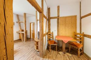 Zimmer mit einem Tisch, Stühlen und Holzwänden in der Unterkunft Ferienhof Domäne Groschwitz in Rudolstadt