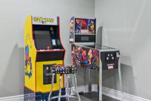 a video game arcade machine next to a bar stool at Modern home with a pool sauna pooltable & mountain view in Collingwood