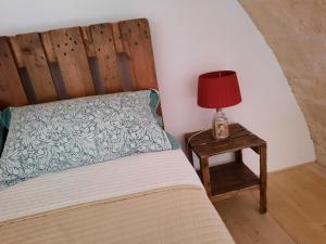 um quarto com uma cama e uma mesa com um candeeiro em B&b la vecchia corte em Copertino