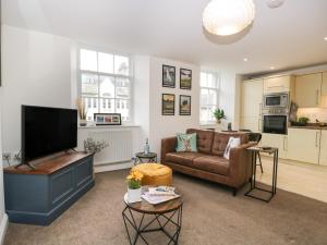 a living room with a couch and a flat screen tv at 3 Old Pharmacy Court in Kendal