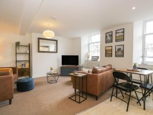 a living room with a couch and a tv at 3 Old Pharmacy Court in Kendal