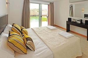 Un dormitorio con una cama grande con almohadas amarillas y blancas en Salobre Vista Golf 27, en Maspalomas