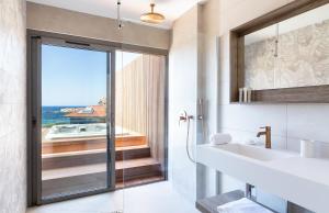 a bathroom with a sink and a view of the ocean at RESIDENCE SANTA MARIA in LʼÎle-Rousse